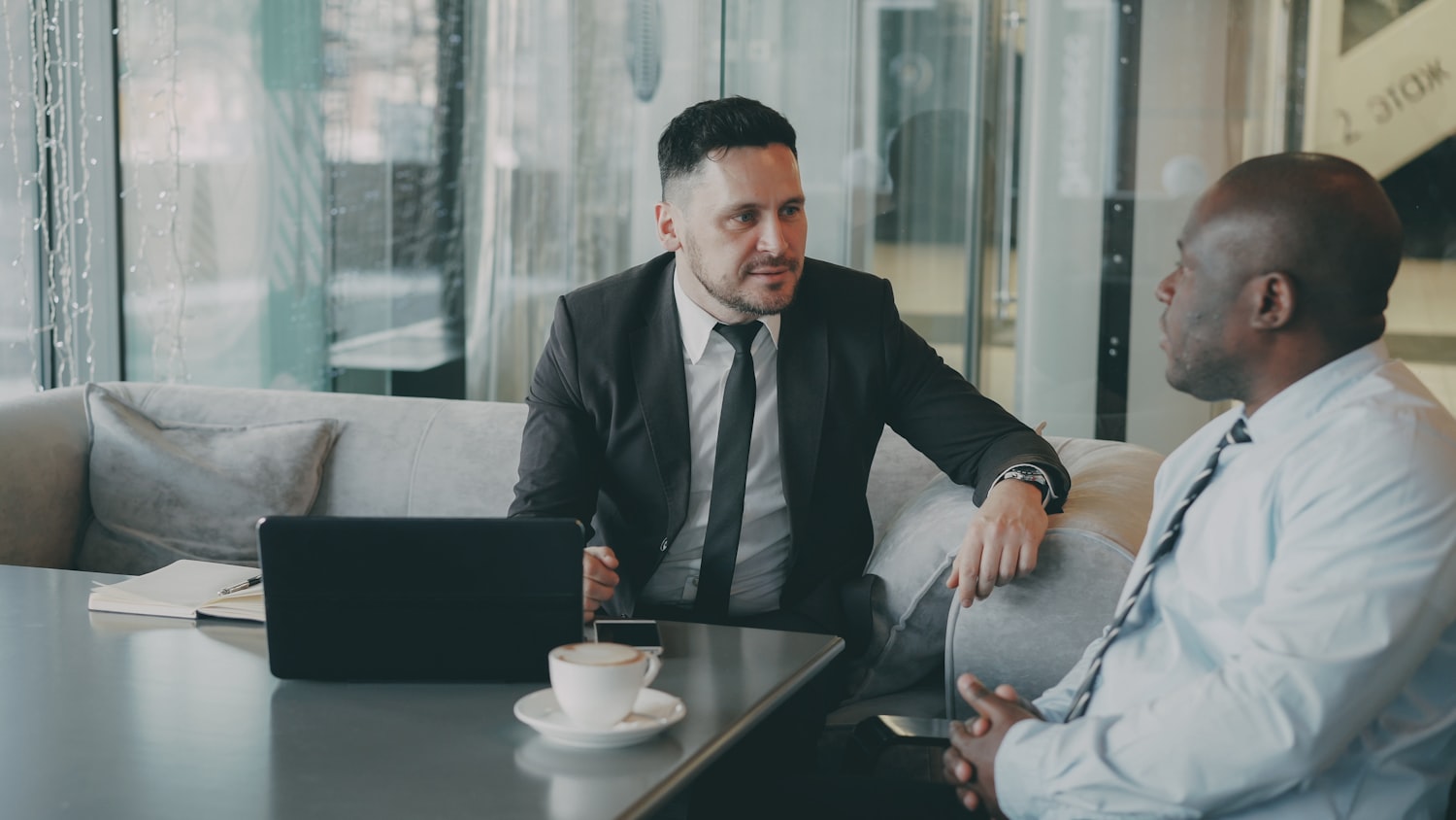 A working session: two people at a table with a laptop